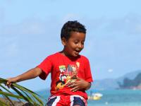 Junge auf Palmstamm - Praslin